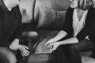 Dr. Ruth Viehoff is seated and leaning towards a male therapy client in her Indianapolis office.