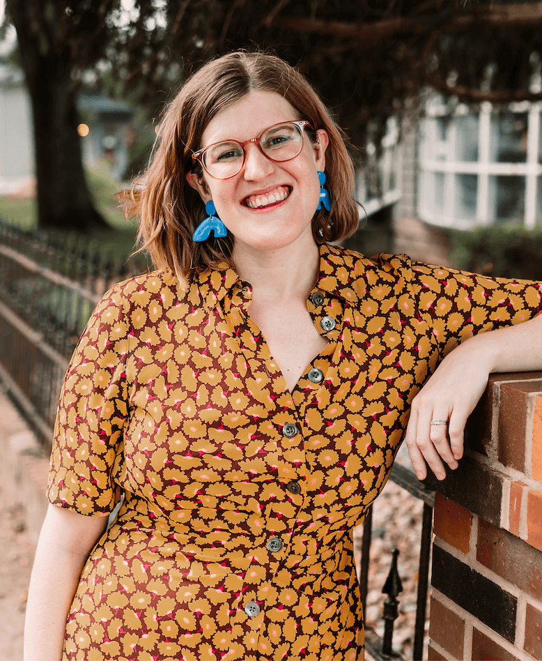 Anxiety therapist and clinical psychologist Dr. Ruth Viehoff is smiling in a yellow dress outside of her Indianapolis therapy office.